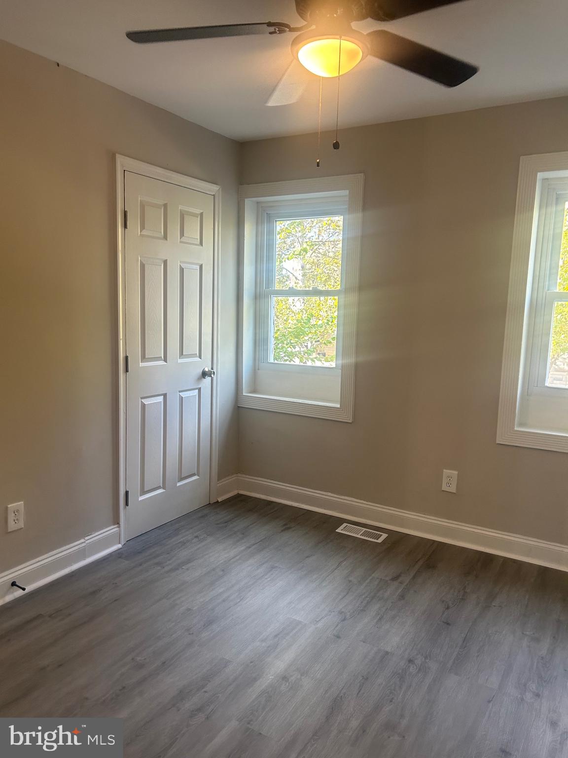 1823 Ramsay Street Baltimore, MD 21223 - Photo 7 of 13 an empty room with wooden floor and windows