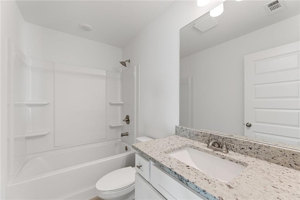 5629 Overview Drive Flowery Branch, GA 30542 - Photo 13 of 25 a bathroom with a granite countertop sink toilet tub and shower