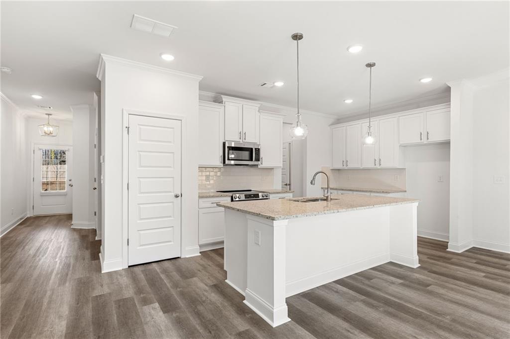 5629 Overview Drive Flowery Branch, GA 30542 - Photo 20 of 25 a kitchen with stainless steel appliances granite countertop a sink a stove a refrigerator and a oven with wooden floor
