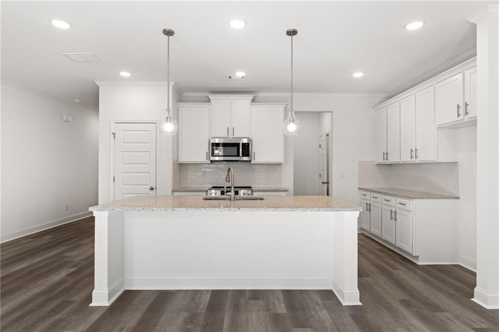 5629 Overview Drive Flowery Branch, GA 30542 - Photo 21 of 25 a large kitchen with stainless steel appliances a large counter top a stove a sink and a refrigerator