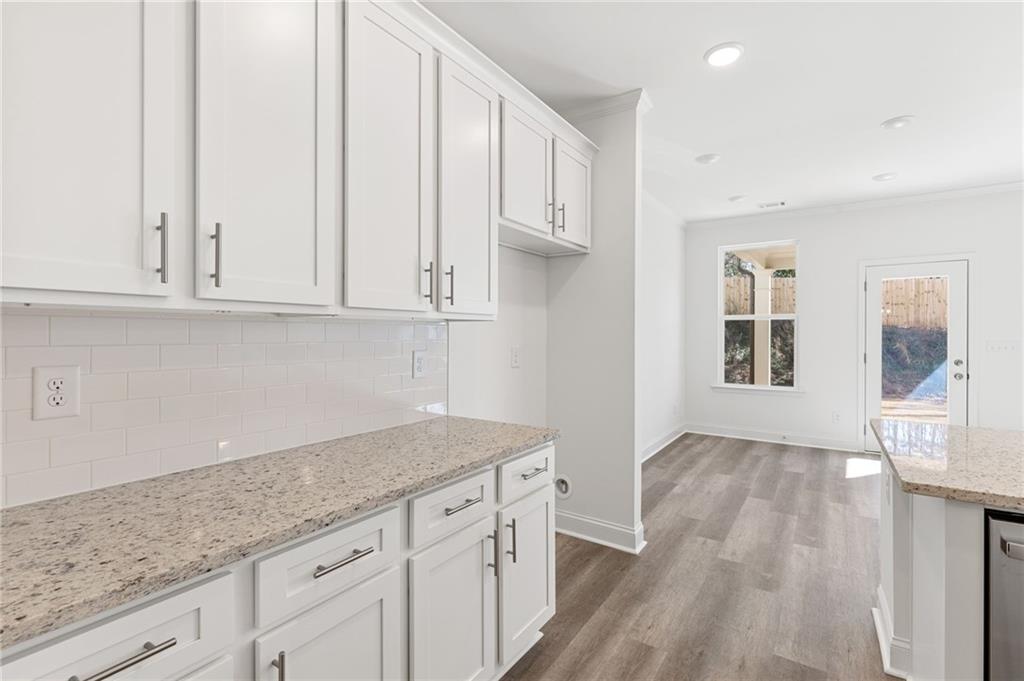 5629 Overview Drive Flowery Branch, GA 30542 - Photo 3 of 25 a kitchen with granite countertop a sink and dishwasher with white cabinets