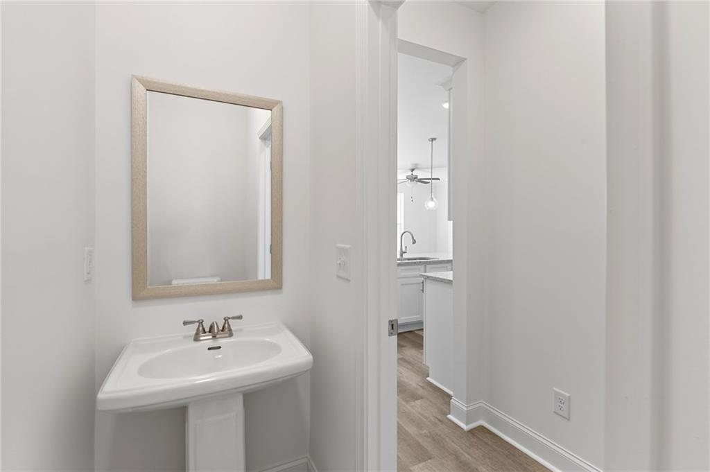 5629 Overview Drive Flowery Branch, GA 30542 - Photo 4 of 25 a bathroom with a sink a mirror and wooden floor