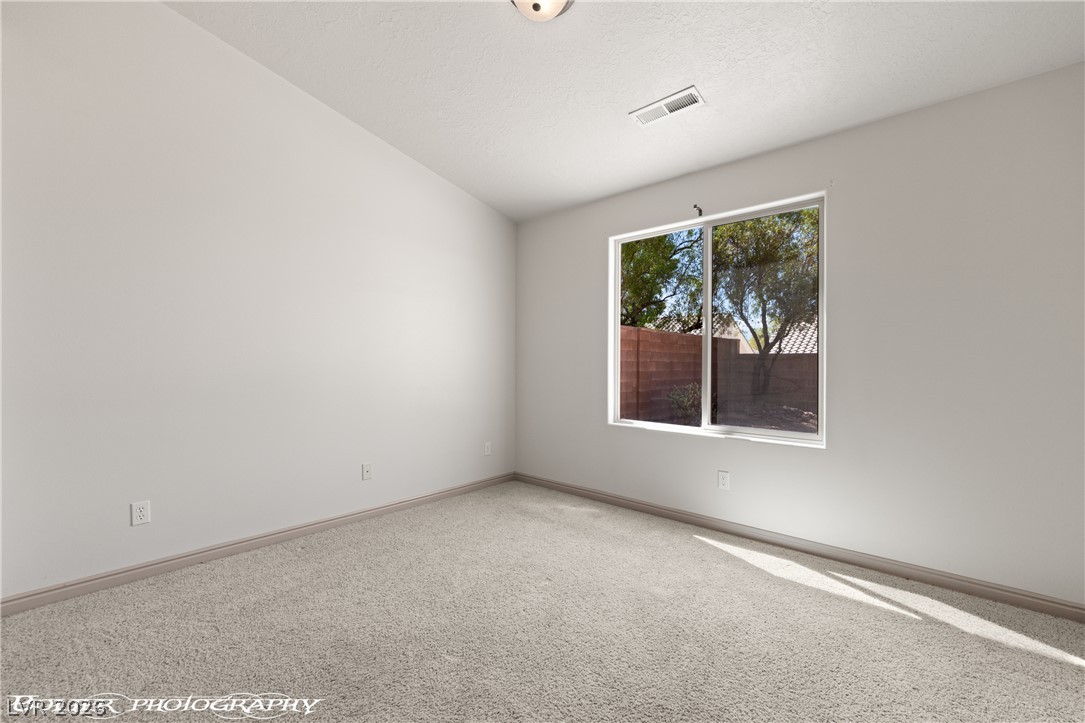 874 Glendale Road Mesquite, NV 89027 - Photo 49 of 71 A well-lit bedroom features ample natural illumination and soft carpeting, creating a tranquil space.