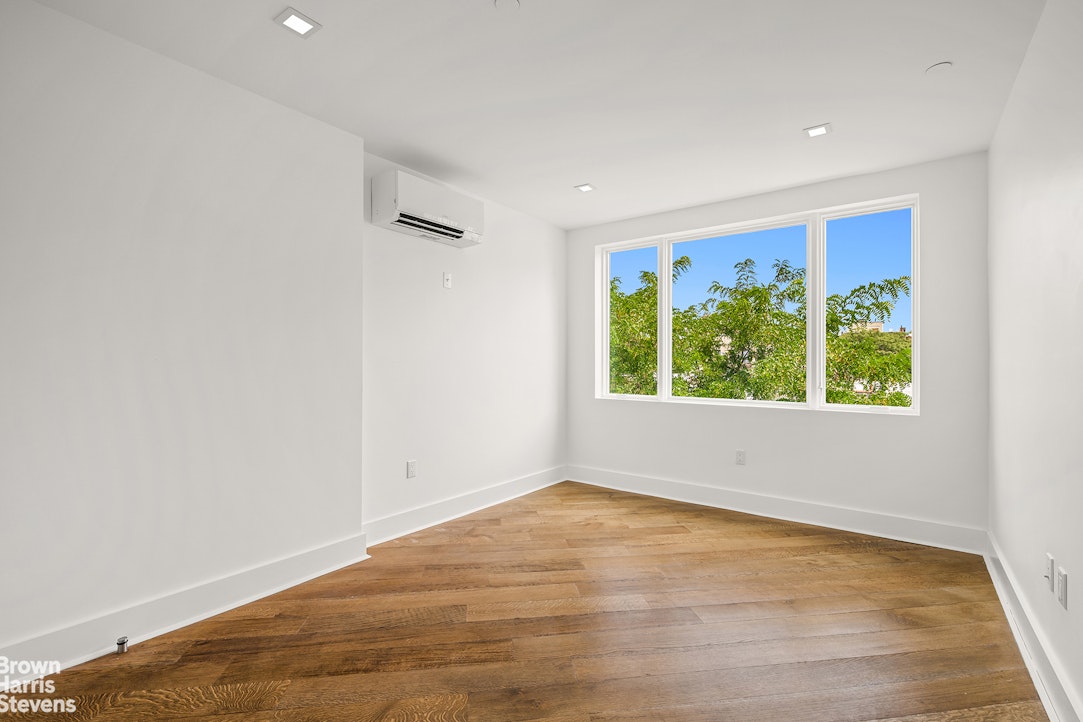 553 West 182nd Street, Unit 5R Manhattan, NY 10033 - Photo 7 of 12 an empty room with wooden floor and windows