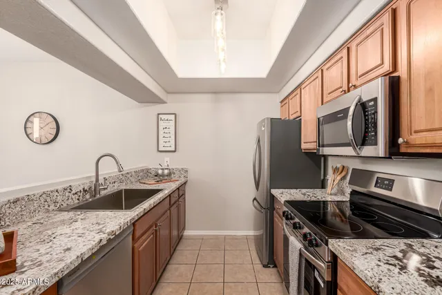 a kitchen with stainless steel appliances granite countertop a sink stove and refrigerator