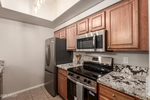 a kitchen with stainless steel appliances granite countertop a stove microwave and refrigerator