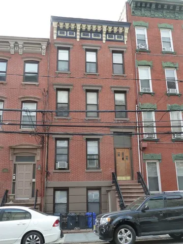 a front view of a building with car parked