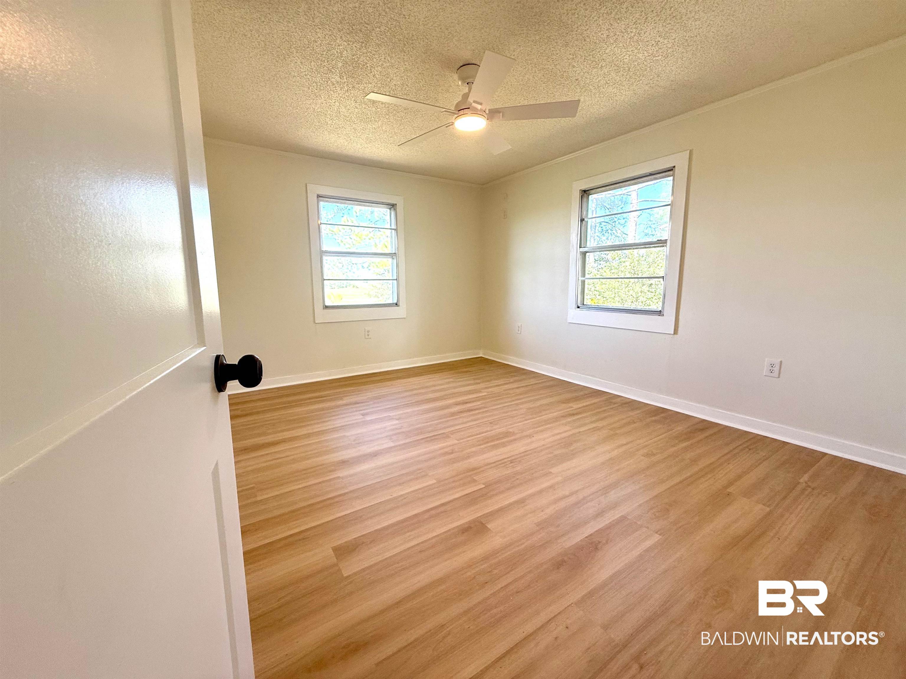 11698 Poser Road Foley, AL 36535 - Photo 12 of 20 Unfurnished room with light wood-style flooring, a textured ceiling, crown molding, and ceiling fan