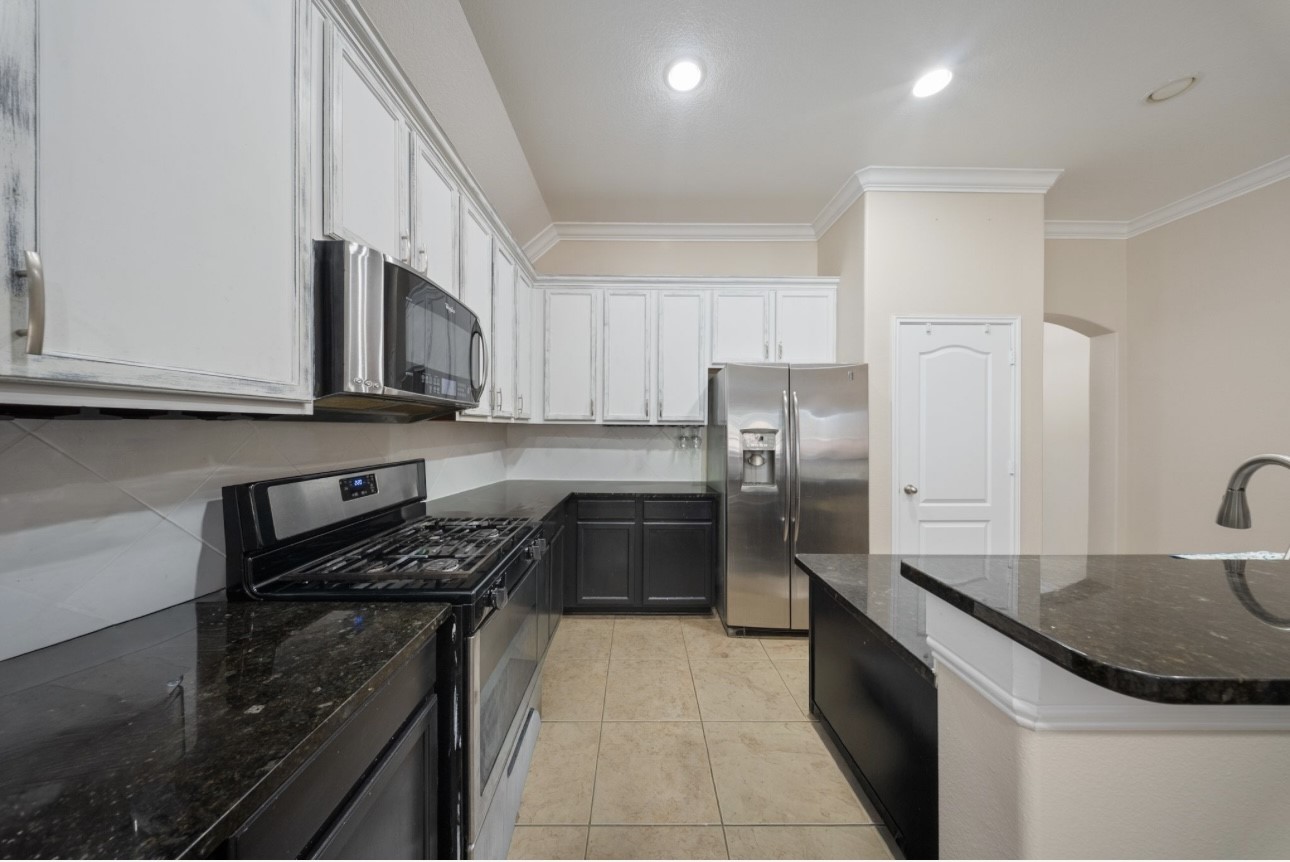 6130 Flagg Ranch Drive Spring, TX 77388 - Photo 4 of 15 a kitchen with stainless steel appliances a sink a stove a microwave a refrigerator a sink and cabinets