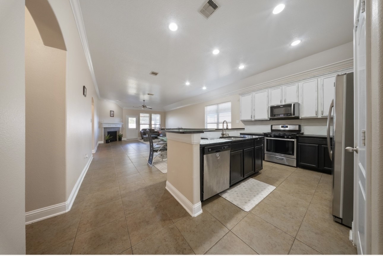 6130 Flagg Ranch Drive Spring, TX 77388 - Photo 6 of 15 a kitchen with stainless steel appliances kitchen island granite countertop a stove top oven a sink and a refrigerator