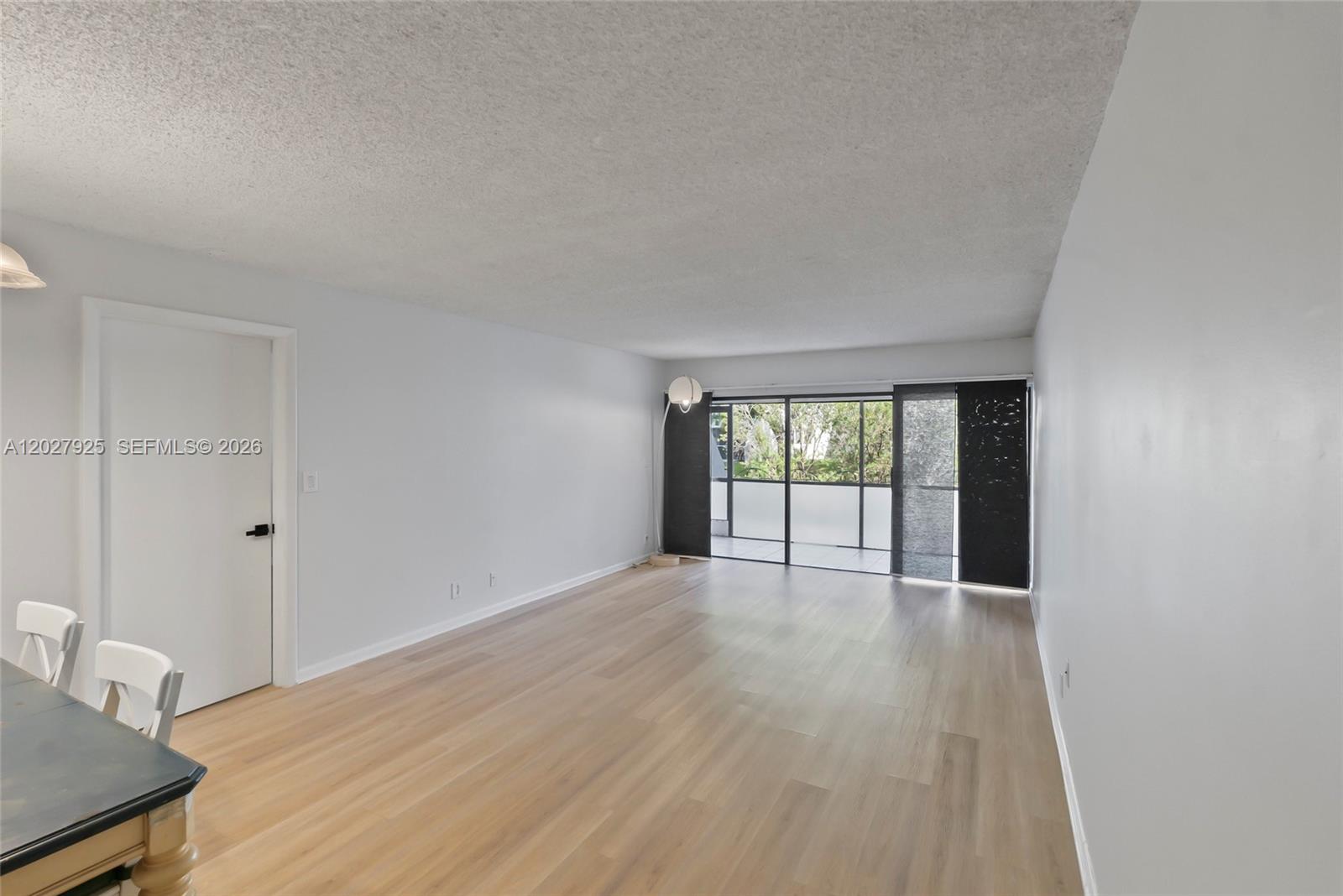 301 Racquet Club Road, Unit 103 Weston, FL 33326 - Photo 16 of 20 a view of an empty room with wooden floor and a window