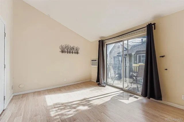 a view of a room with wooden floor and a large window
