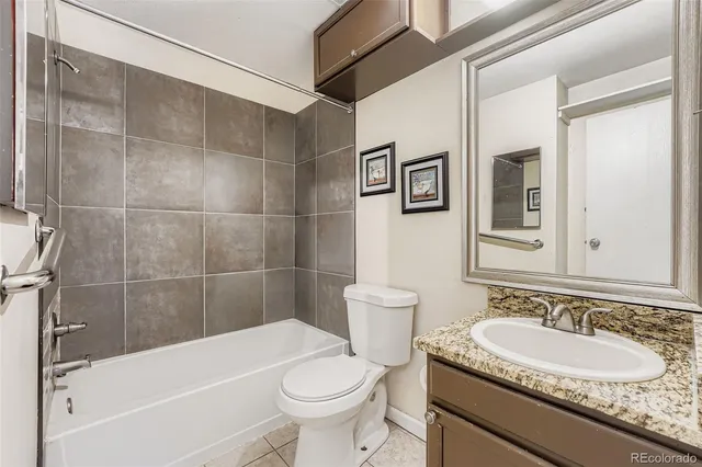 a bathroom with a granite countertop sink toilet and a mirror