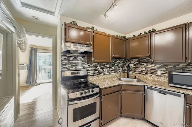 a kitchen with stainless steel appliances a stove and white cabinets