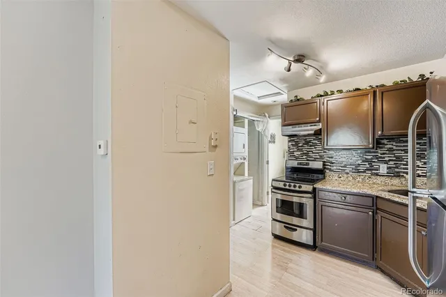 a view of empty room with windows and refrigerator