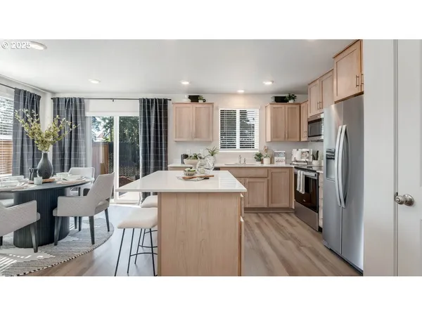 a kitchen with a table chairs refrigerator and chairs