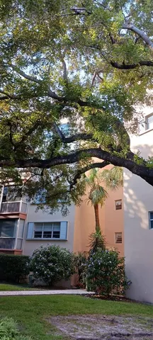 a balcony with couple of glass top table and chairs