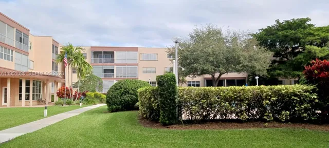 a view of a backyard with potted plants and large trees