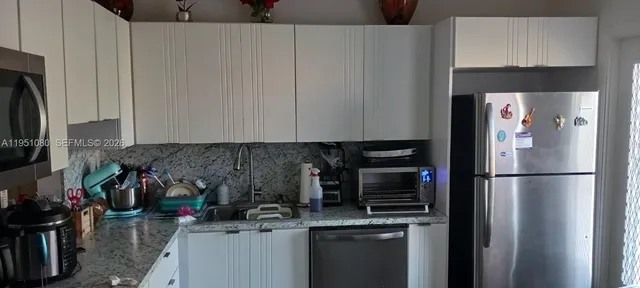 a kitchen with a refrigerator and a sink
