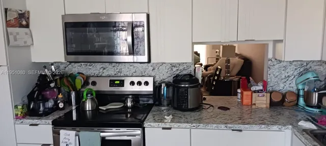 a kitchen with an oven a cabinets and appliances