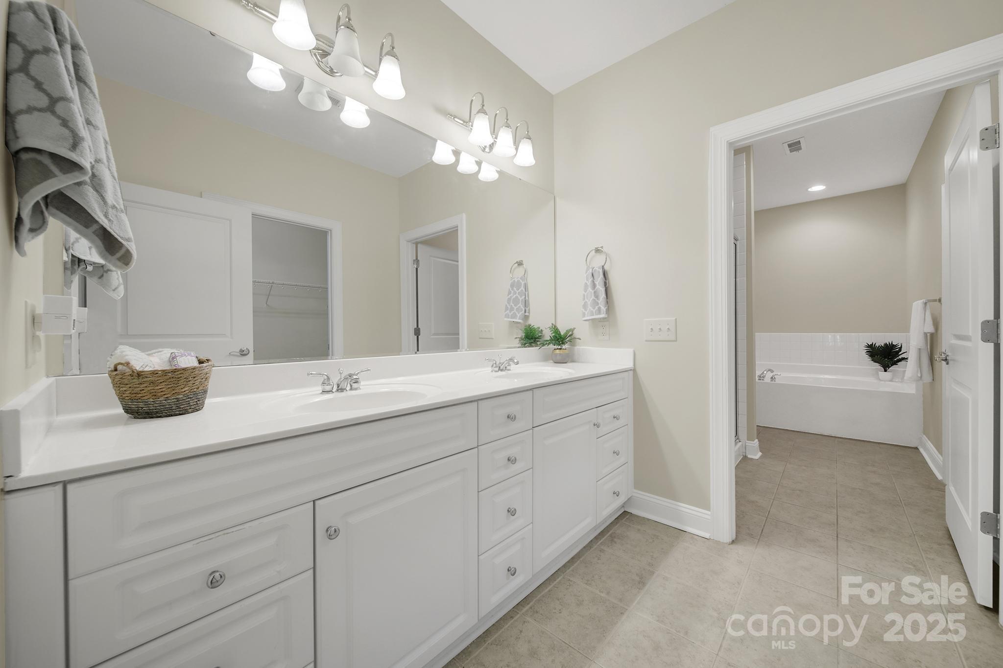 2959 Bellasera Way Matthews, NC 28105 - Photo 16 of 30 a bathroom with a sink a large mirror and a shower