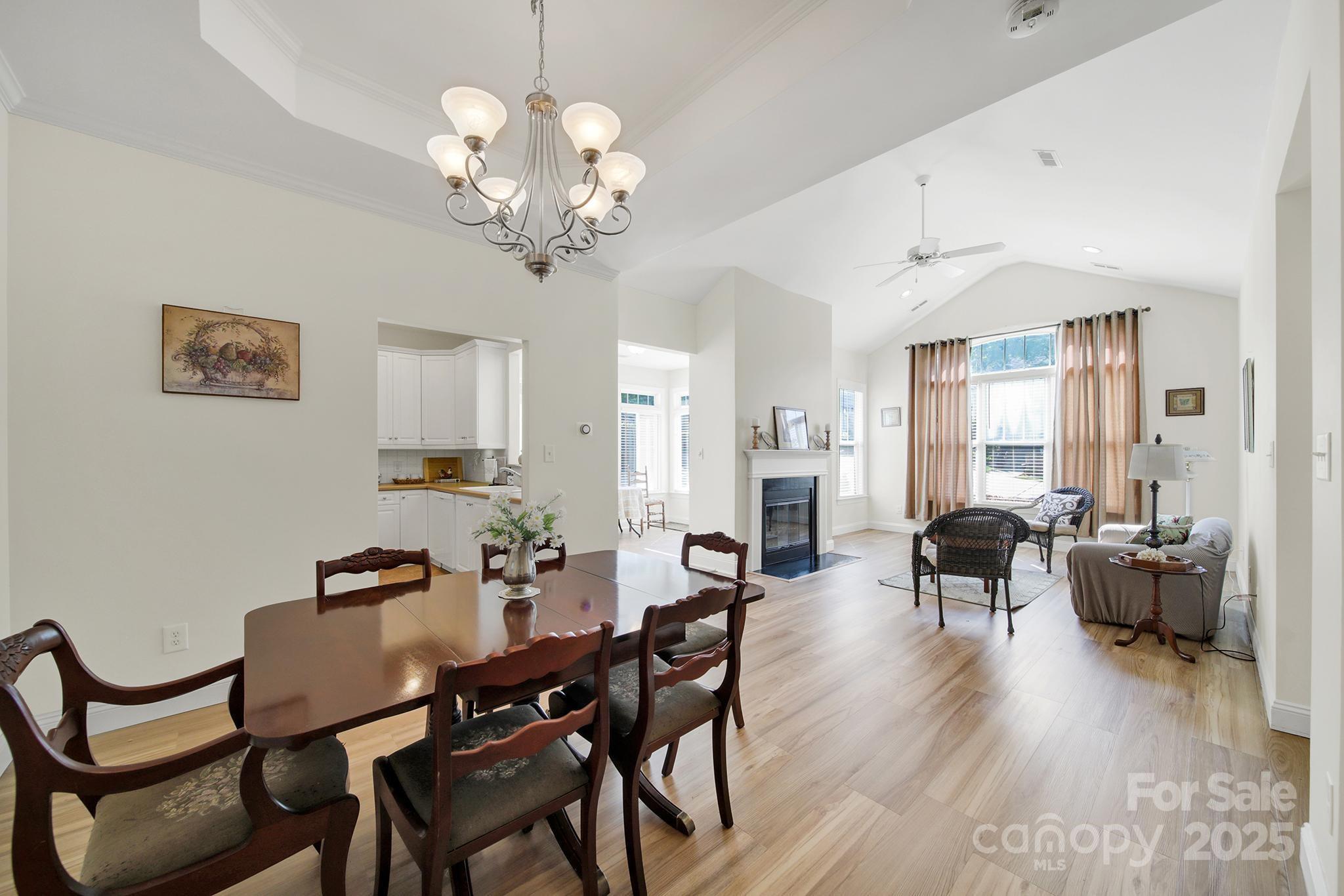 2959 Bellasera Way Matthews, NC 28105 - Photo 4 of 30 a view of a dining room with furniture wooden floor and chandelier