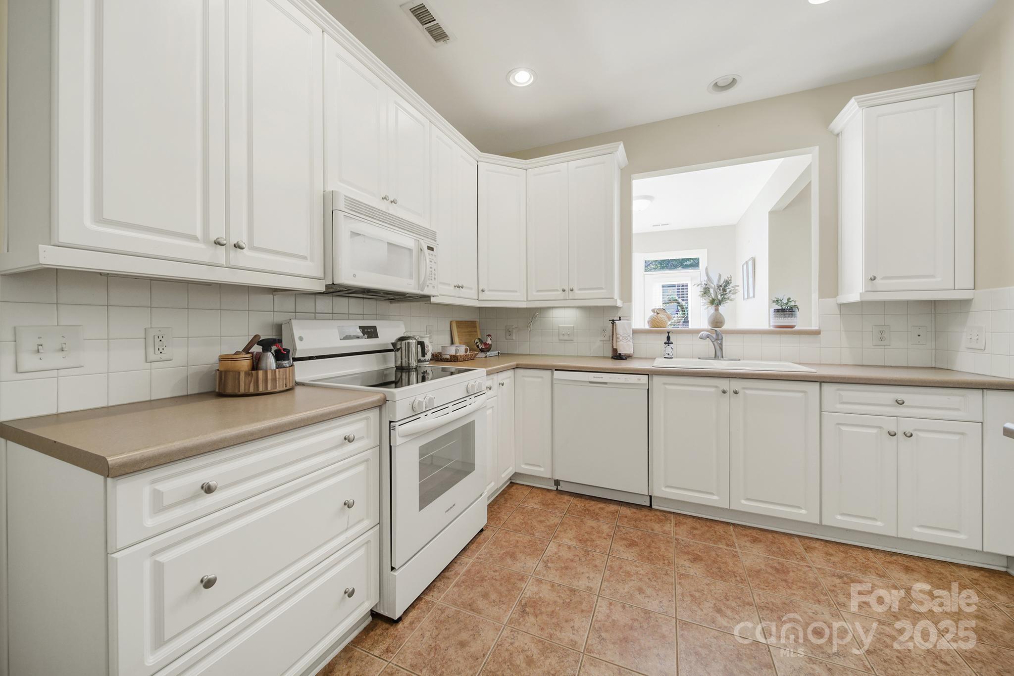 2959 Bellasera Way Matthews, NC 28105 - Photo 8 of 30 a kitchen with cabinets appliances a sink and a window