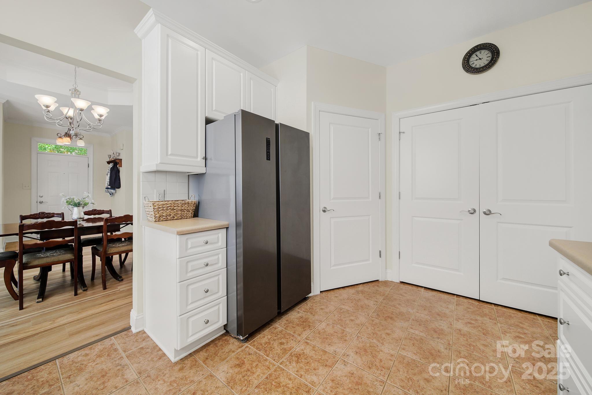 2959 Bellasera Way Matthews, NC 28105 - Photo 10 of 30 a kitchen with a refrigerator and white cabinets