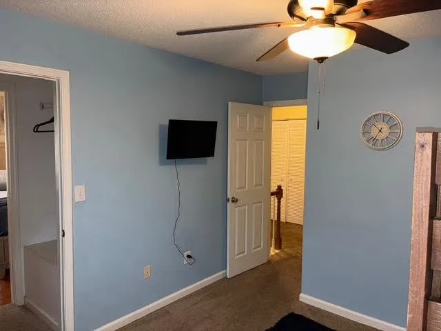 a view of a livingroom with wooden floor and a ceiling fan