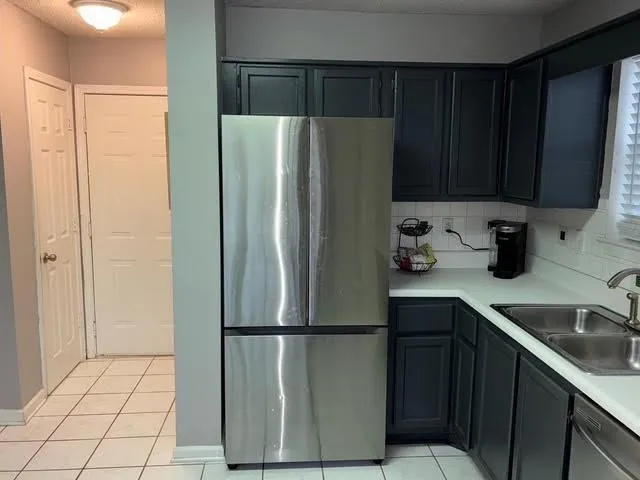 a kitchen with a refrigerator a sink and cabinets
