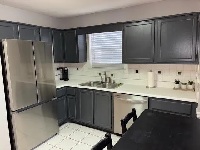 a kitchen with a sink a refrigerator and cabinets