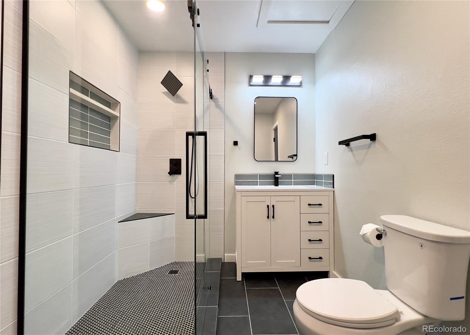 9190 High Street Thornton, CO 80229 - Photo 18 of 28 a bathroom with a toilet sink vanity granite and shower