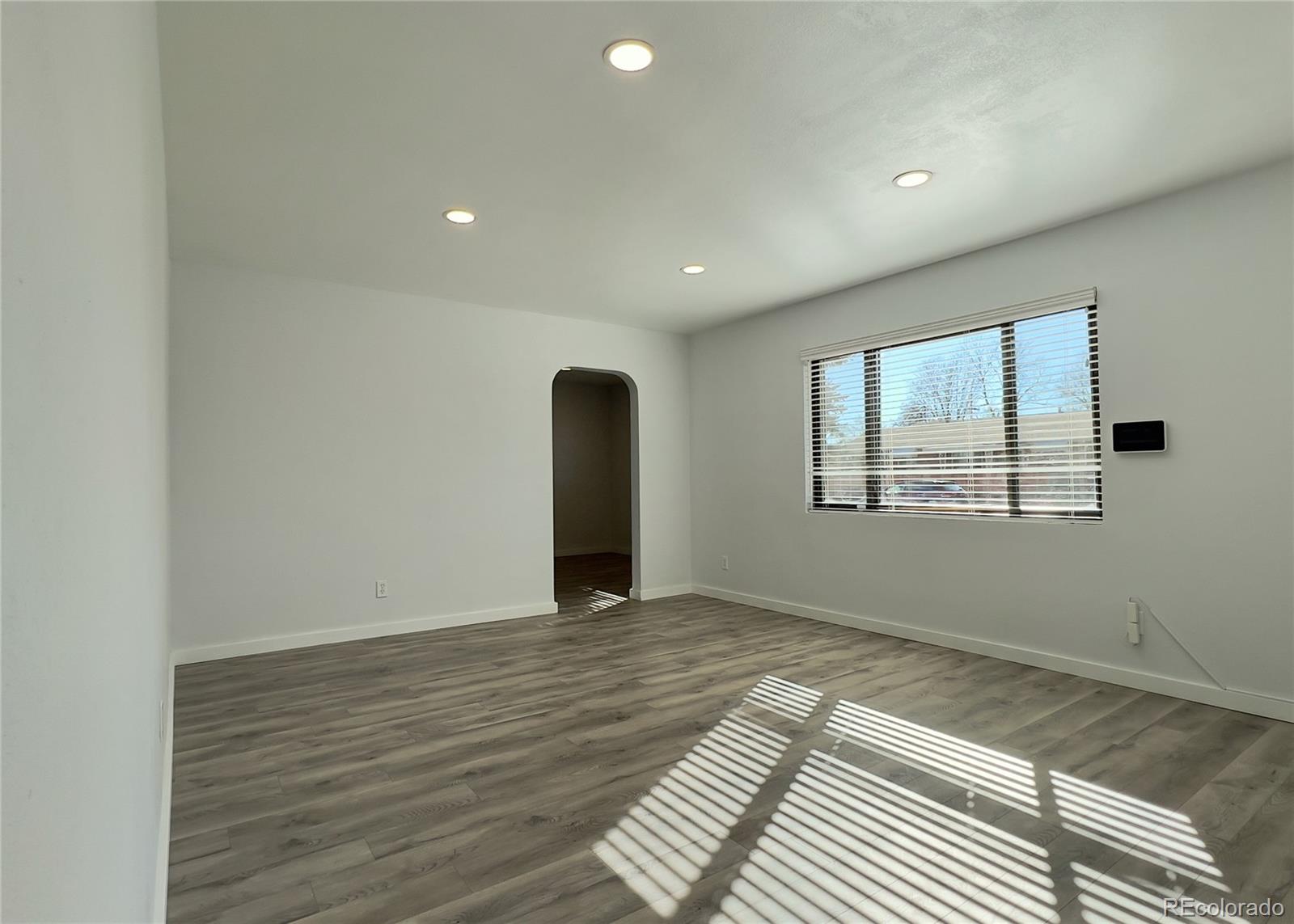 9190 High Street Thornton, CO 80229 - Photo 6 of 28 a view of an empty room with wooden floor and a window