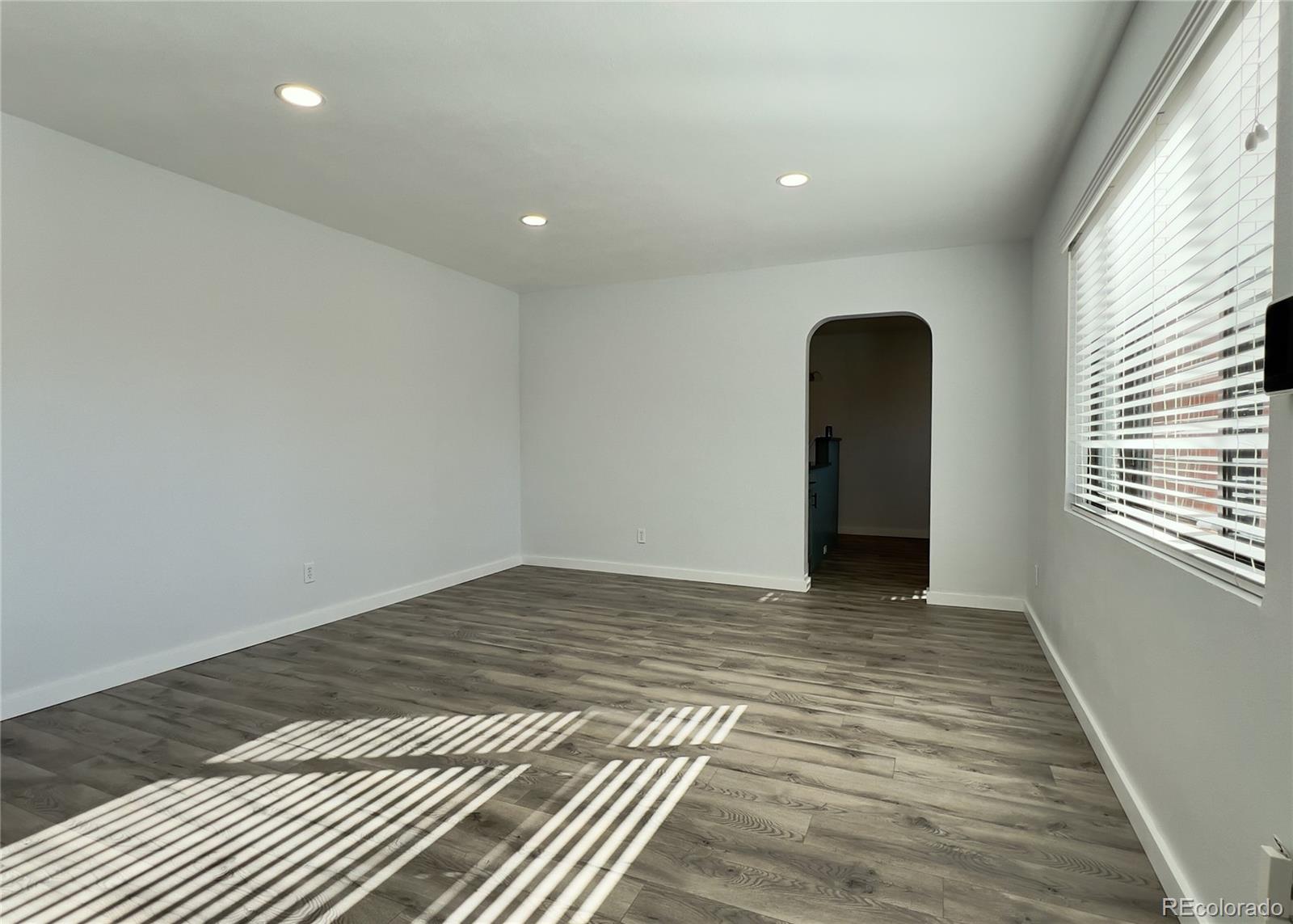 9190 High Street Thornton, CO 80229 - Photo 7 of 28 a view of an empty room with wooden floor and a window