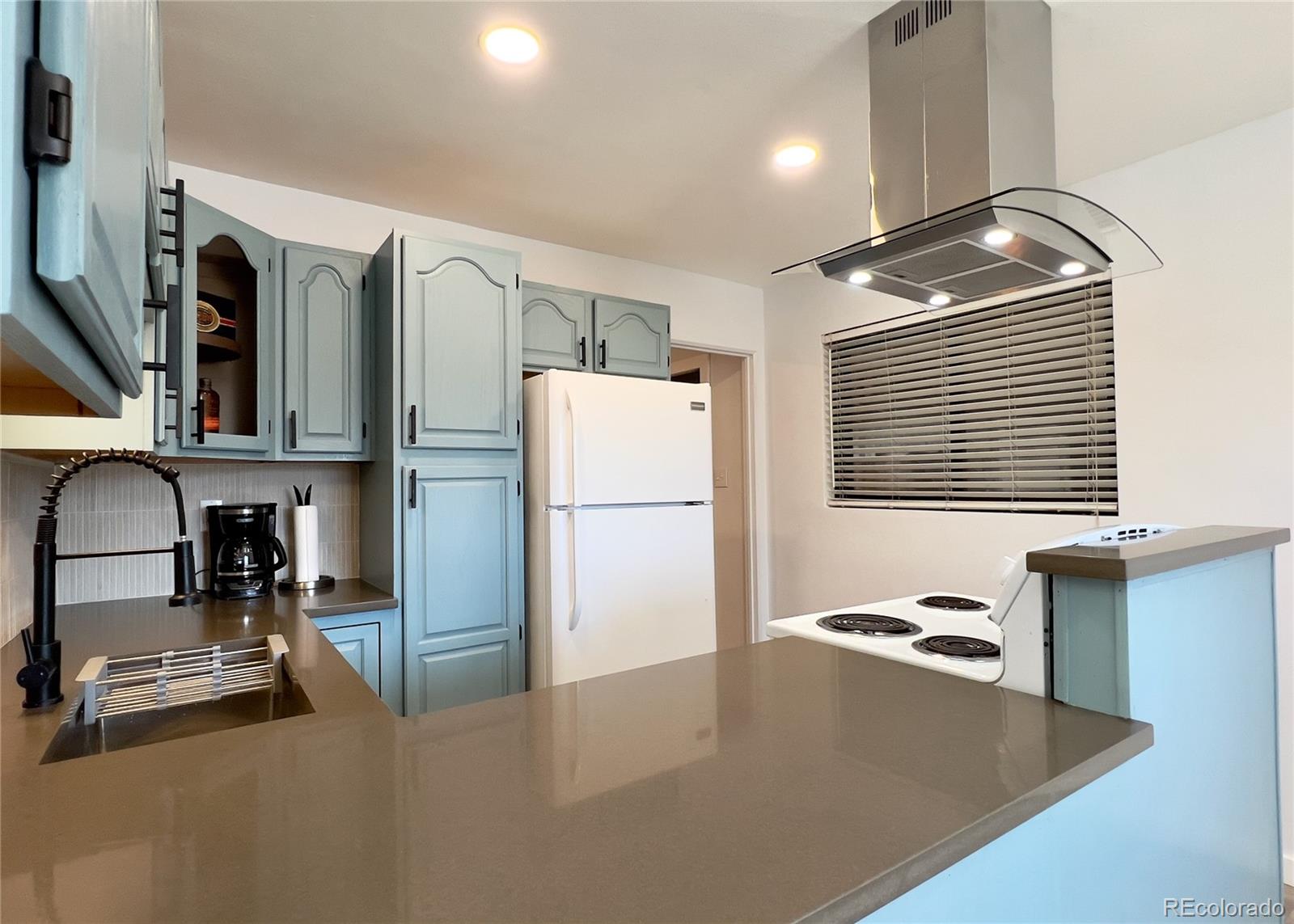 9190 High Street Thornton, CO 80229 - Photo 10 of 28 a kitchen with stainless steel appliances granite countertop a refrigerator a stove and a sink with wooden floor