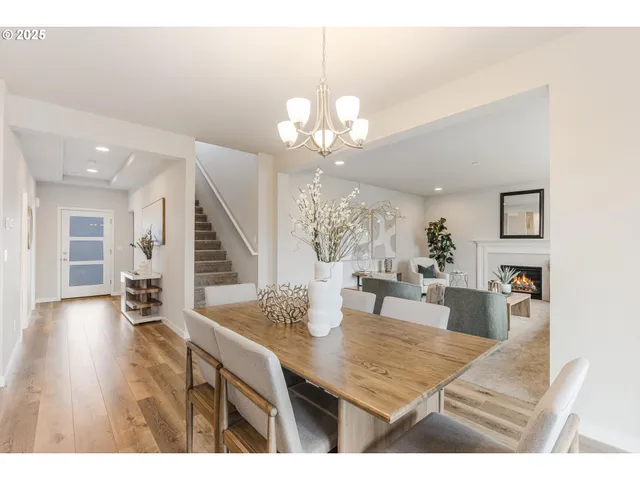 a view of a dining room and livingroom with furniture wooden floor a chandelier