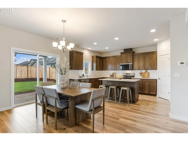 a kitchen with kitchen island a dining table chairs and wooden floor