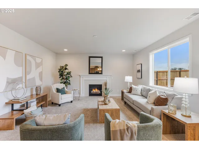 a living room with furniture a fireplace and a large window