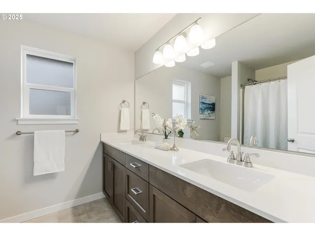 a bathroom with a double vanity sink and a mirror