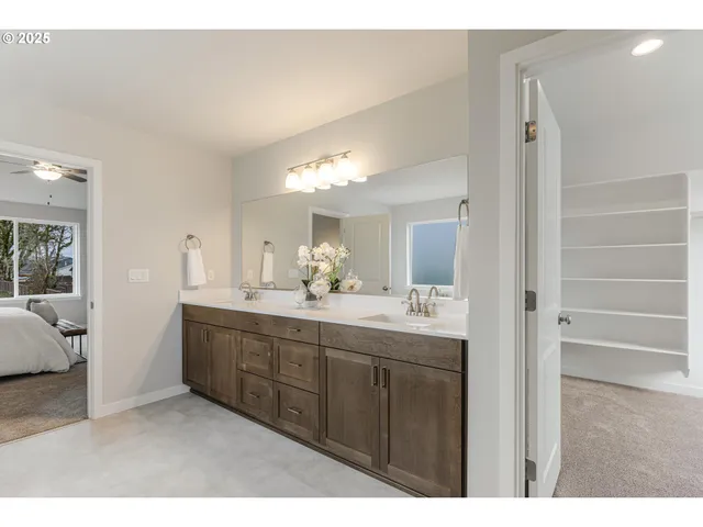 a bathroom with a double vanity sink a mirror and a shower