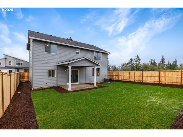 a front view of a house with a yard and trees