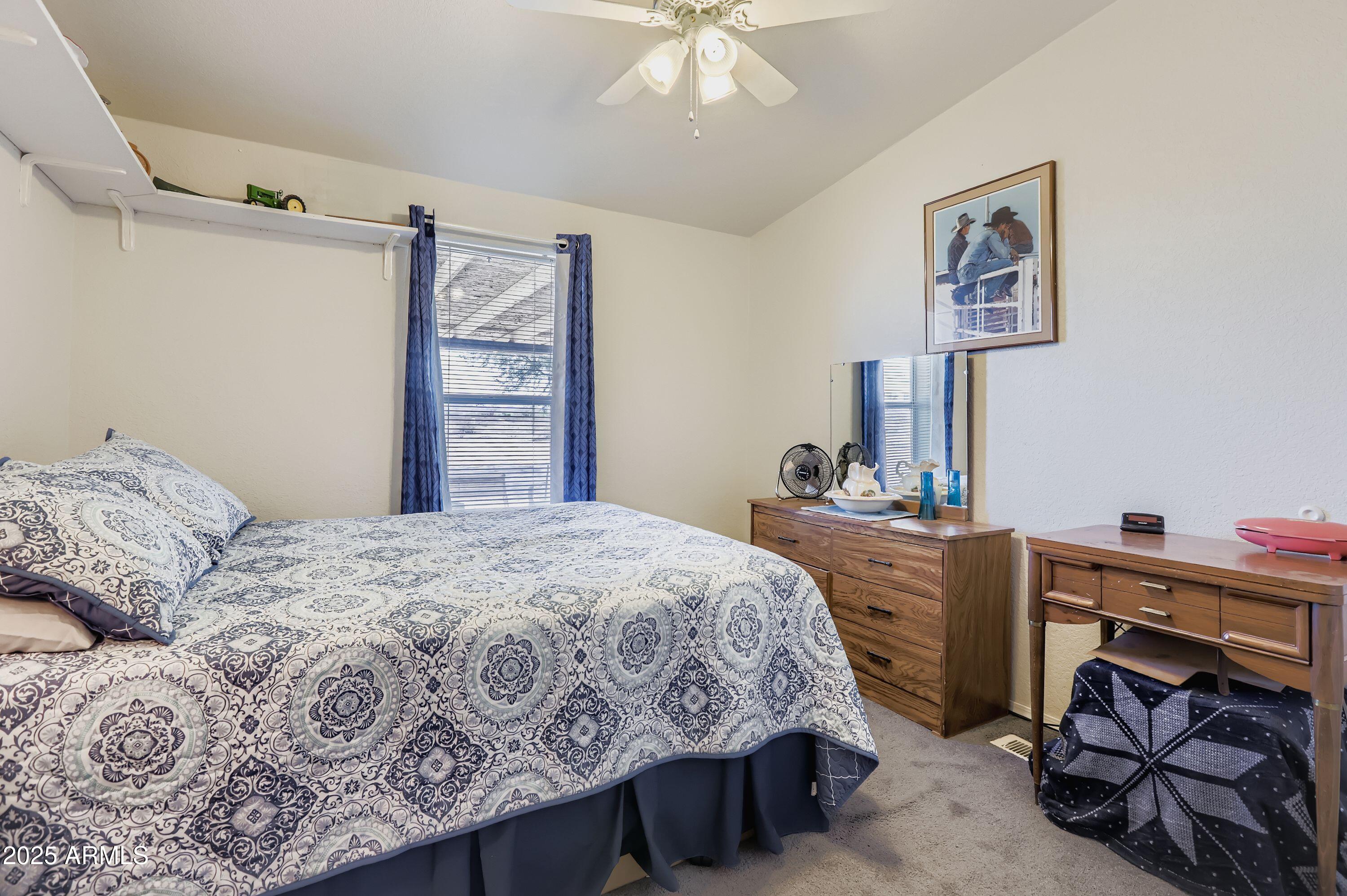 20607 West Chandler Heights Road Buckeye, AZ 85326 - Photo 12 of 29 a bedroom with a bed and a chandelier