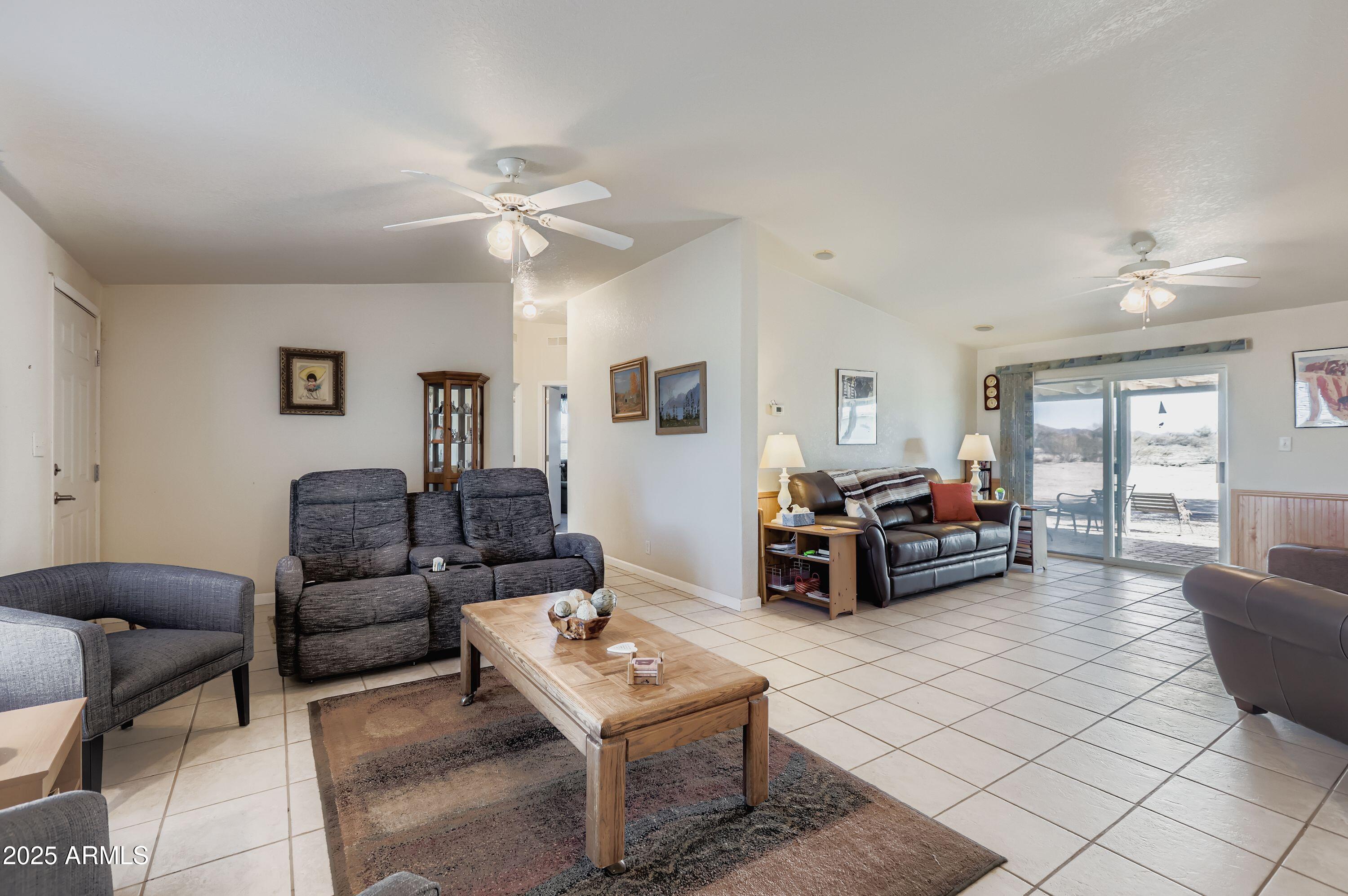 20607 West Chandler Heights Road Buckeye, AZ 85326 - Photo 2 of 29 a living room with furniture and a ceiling fan