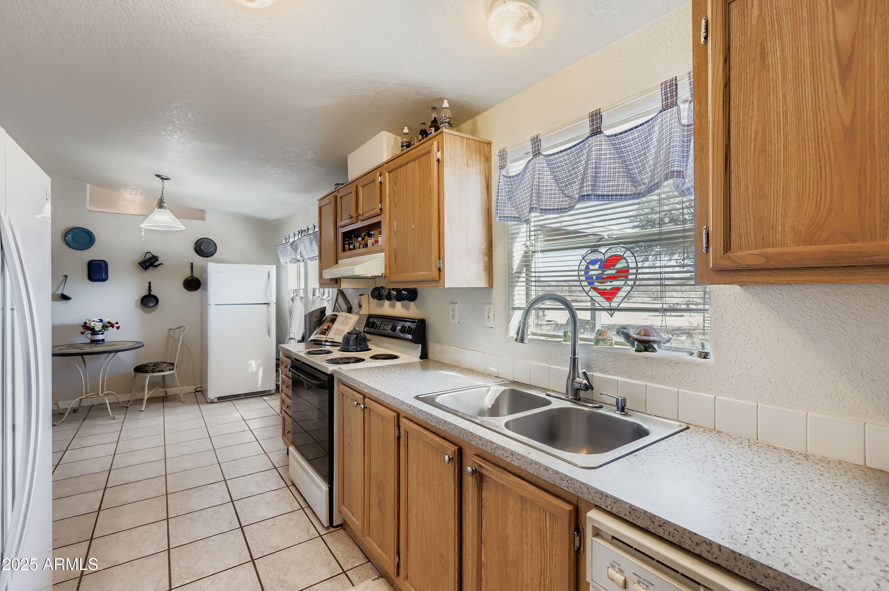 20607 West Chandler Heights Road Buckeye, AZ 85326 - Photo 21 of 29 a kitchen with a sink a stove and cabinets
