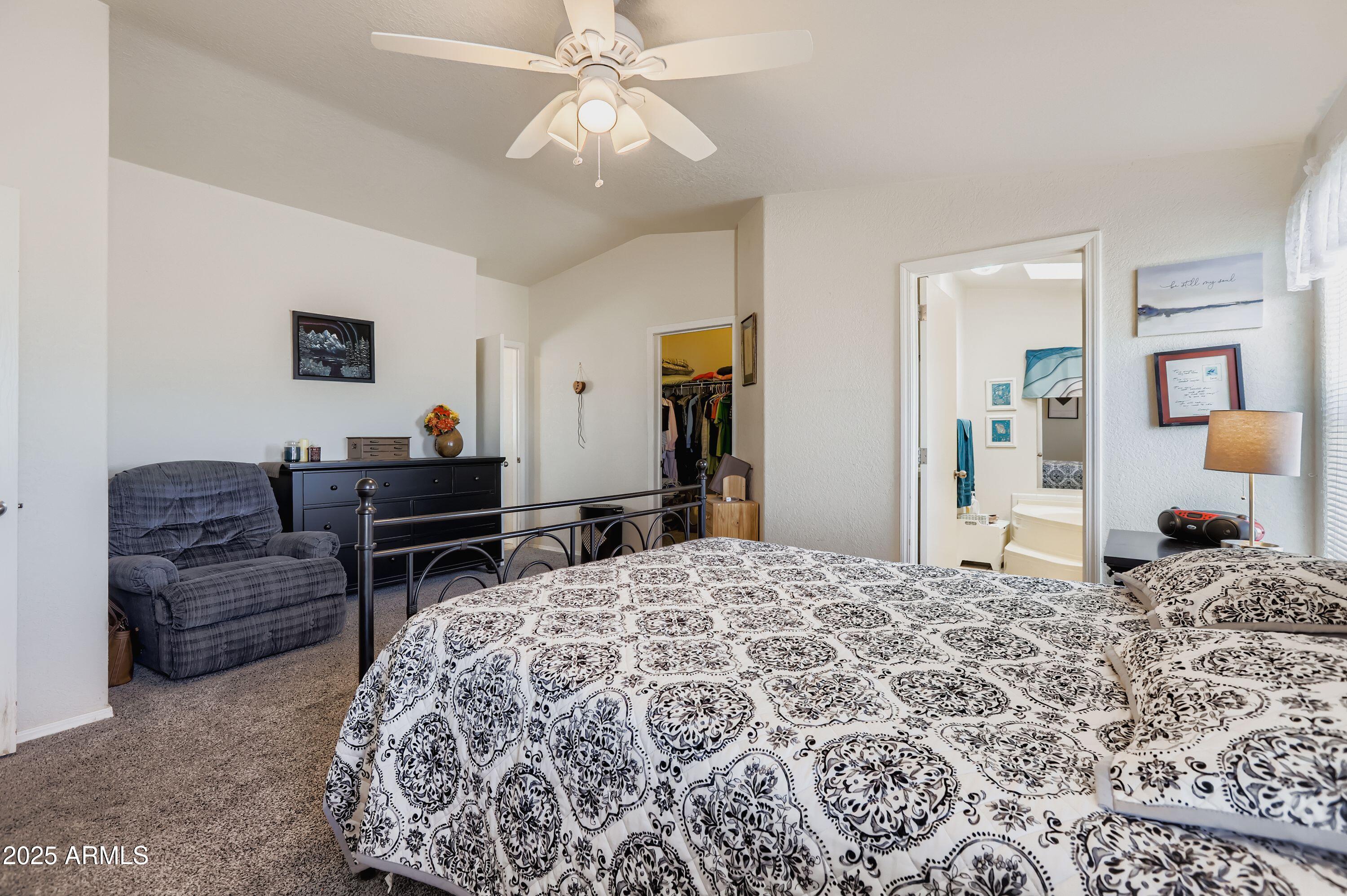 20607 West Chandler Heights Road Buckeye, AZ 85326 - Photo 24 of 29 a living room with a bed and a chandelier