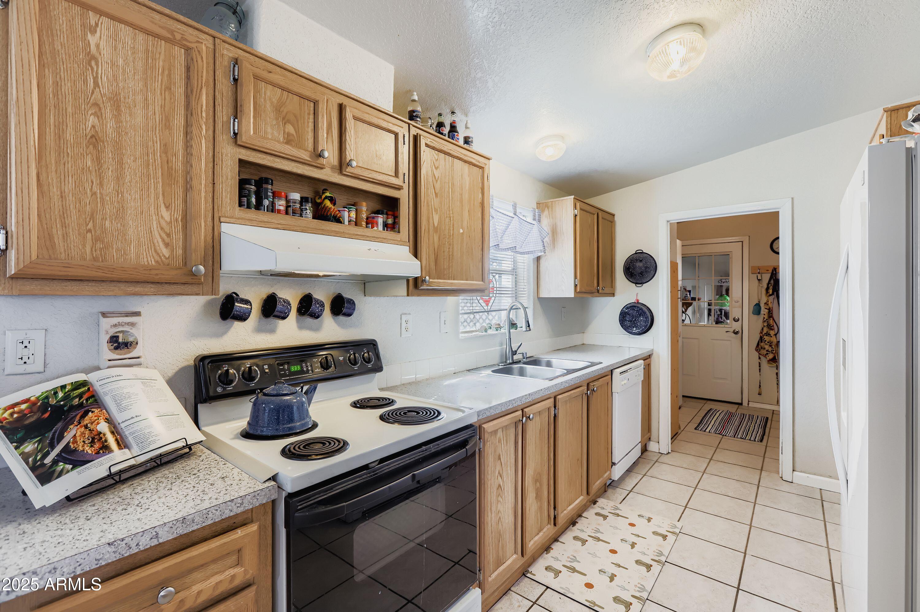 20607 West Chandler Heights Road Buckeye, AZ 85326 - Photo 3 of 29 a kitchen with stainless steel appliances a stove a sink and cabinets