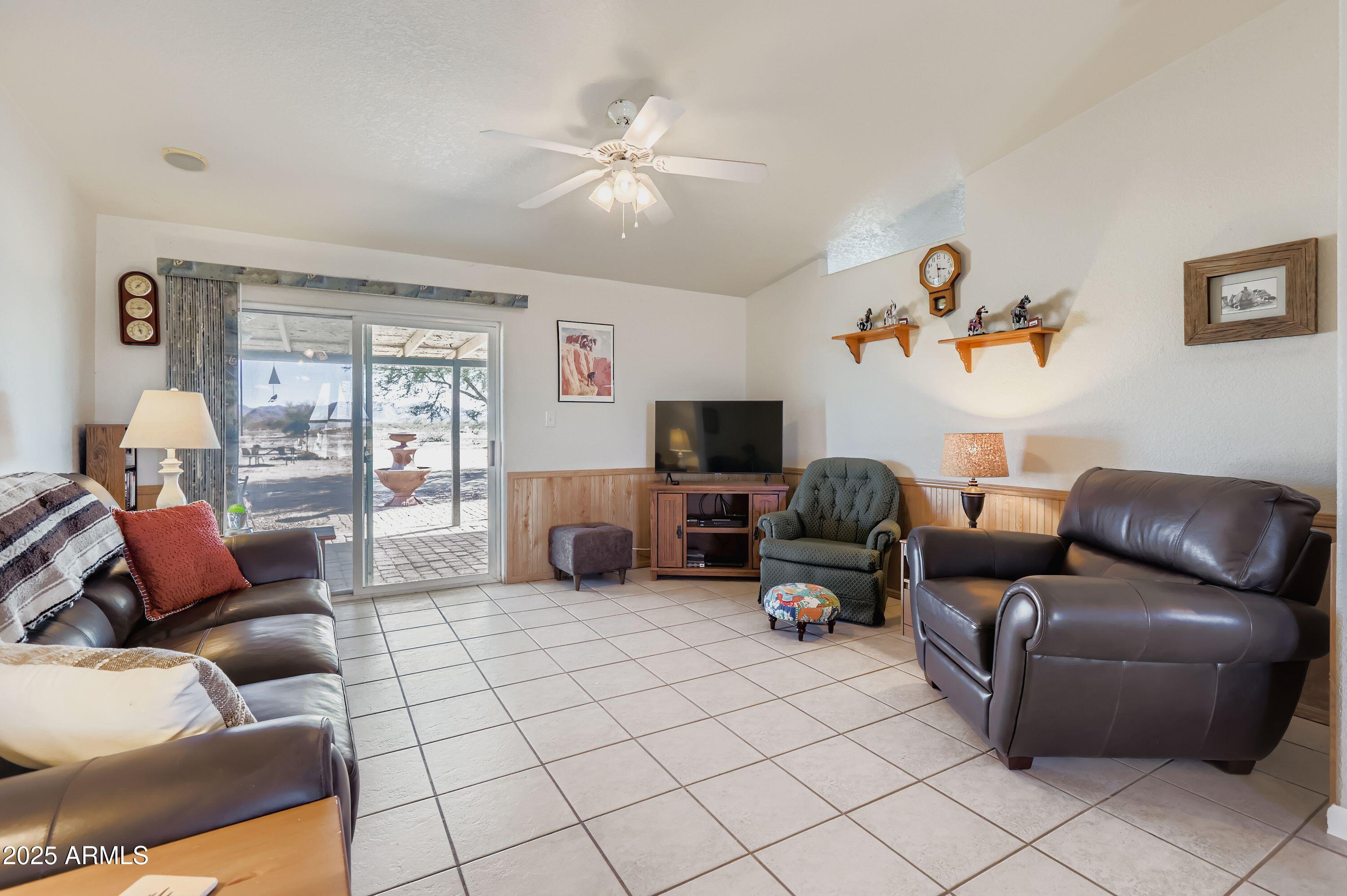 20607 West Chandler Heights Road Buckeye, AZ 85326 - Photo 6 of 29 a living room with furniture and a flat screen tv
