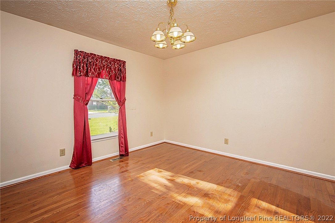 138 Pecan Trace Road Raeford, NC 28376 - Photo 12 of 42 a view of a room with wooden floor and a chandelier