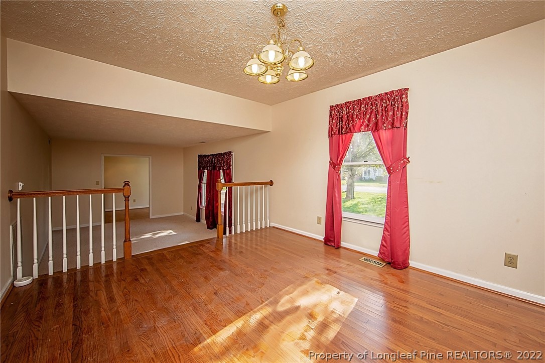 138 Pecan Trace Road Raeford, NC 28376 - Photo 13 of 42 a view of empty room with wooden floor and fan