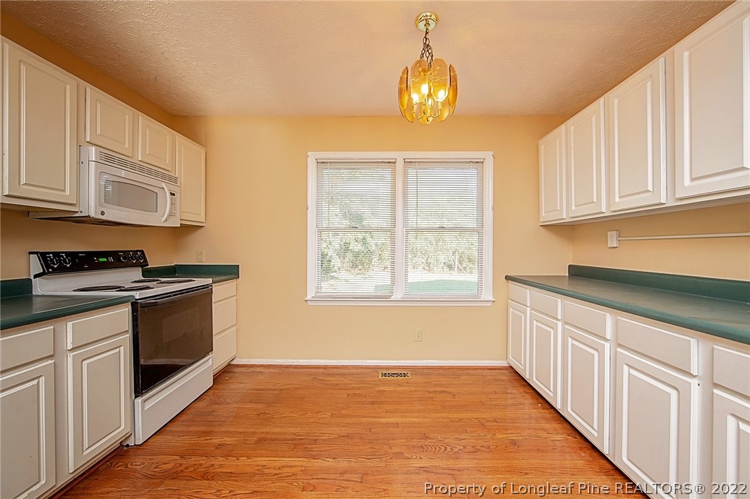 138 Pecan Trace Road Raeford, NC 28376 - Photo 18 of 42 a kitchen with stainless steel appliances granite countertop a stove a sink and a white cabinets